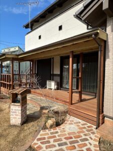 施工後：ウッドデッキとレンガ調の鳥小屋があり、鳥が訪れる庭になった様子